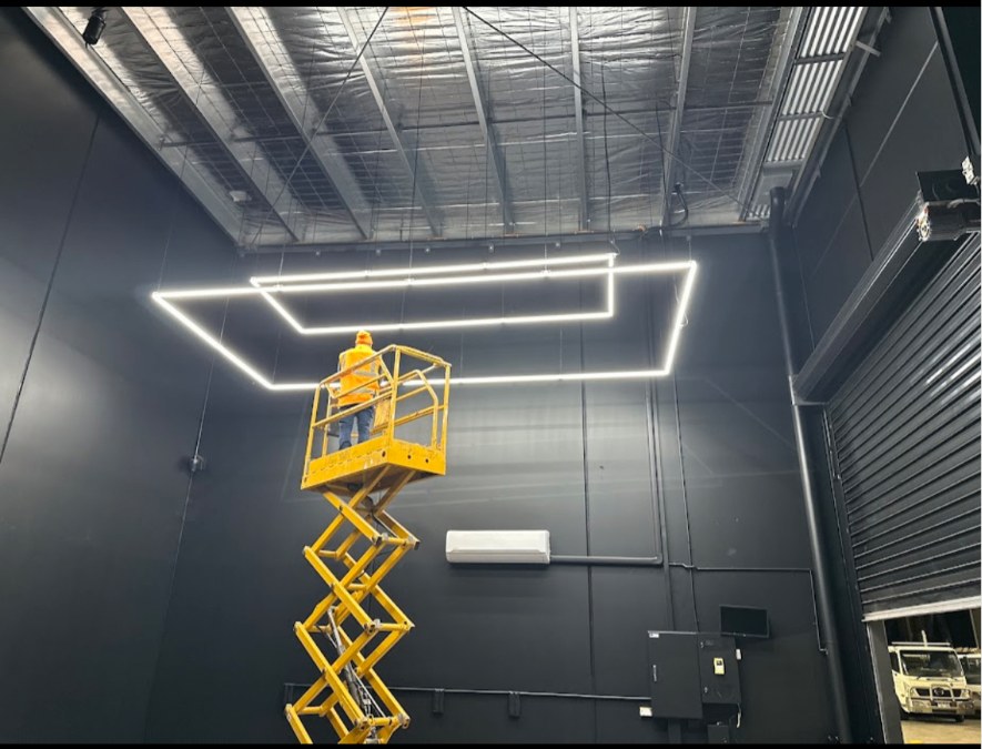 Electrician on a scissor lift installing feature lighting